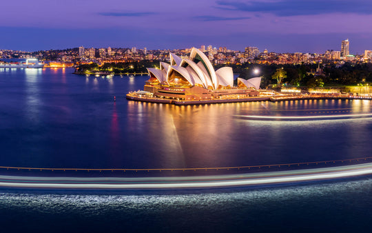 A ferry boat passes in front of the Sydney Opera House